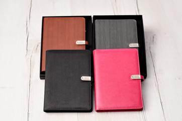 Set of diary or notebook in hard leather cover on wood table. Four leather notebooks on wooden background. Copy space..