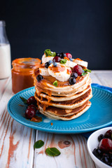 Delicious and lush pancakes with fresh fruits and berries, poured with salted caramel.