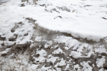 Dirty snow spring background. Old and dirty snow texture. Natural background. Snow mixed with coal soot, poor ecology. Environmental pollution.