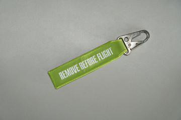 Green remove before flight airplane safety label isolated on white close up.