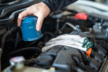 Professional mechanic man holding oil filter for repair and maintenance the car