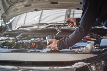 Professional mechanic man holding wrench tool for remove and replace oil filter, repair and maintenance car service