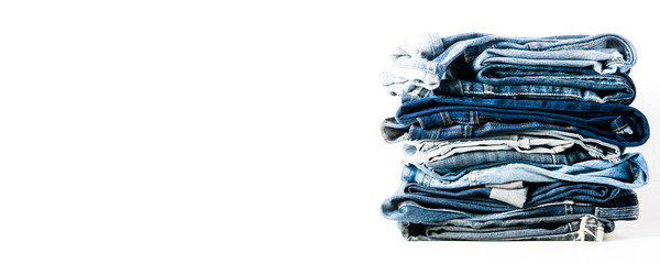 A stack of old jeans isolated on a light background