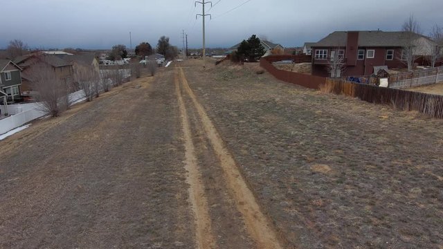 Road to sky pan upward as the drone flies toward a dark sky under high voltage power lines.