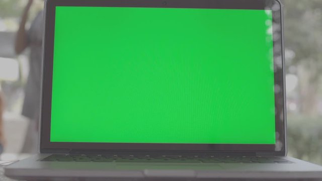 4K Green screen of laptop computer set on working space .