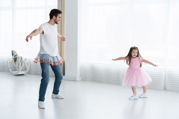 Fototapeta premium I love you, dad! Handsome young man is dancing at home with his little girl. Happy Father's Day!