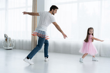 I love you, dad! Handsome young man is dancing at home with his little girl. Happy Father's Day!