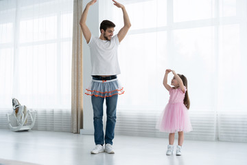 I love you, dad! Handsome young man is dancing at home with his little girl. Happy Father's Day!