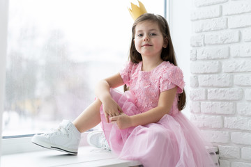Cute little girl in a princess costume. Pretty child preparing for a costume party. Beautiful queen in gold crown. © opolja