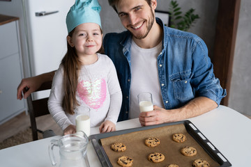 father and daughter making cookies in kitchen