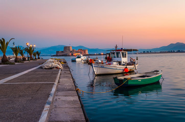 Fototapeta na wymiar Nafplio Greece- View of the beautiful port of Nafplio with small boats and the castle of Bourtzi at sunset.