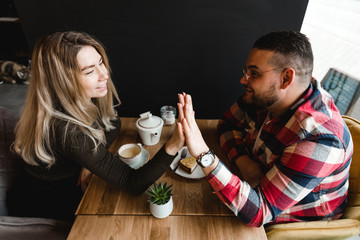 Man and woman dating in cafe. Happy guy and girl. Couple in love sitting at home and communicating. Close up of a happy couple enjoying time together