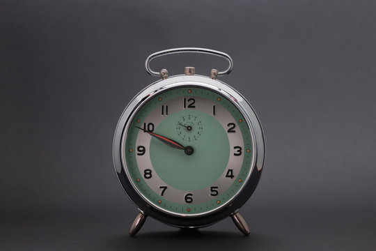 Vintage iron alarm clock, on a gray background. wake up tim