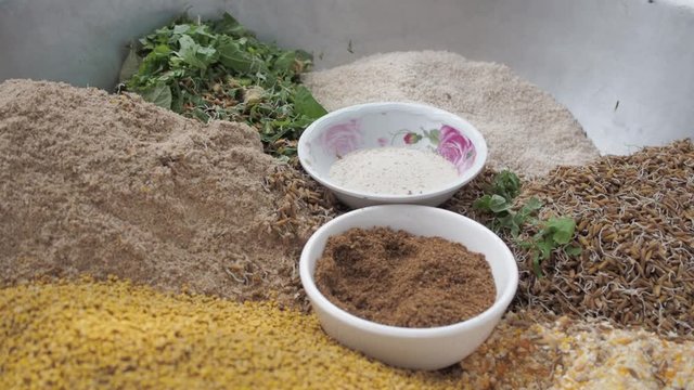 Multiple ingredients in a metal pan for nutritious chicken feed, forward shot