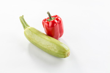 raw bell pepper, fresh zucchini whole uncooked isolated on white background with shadow