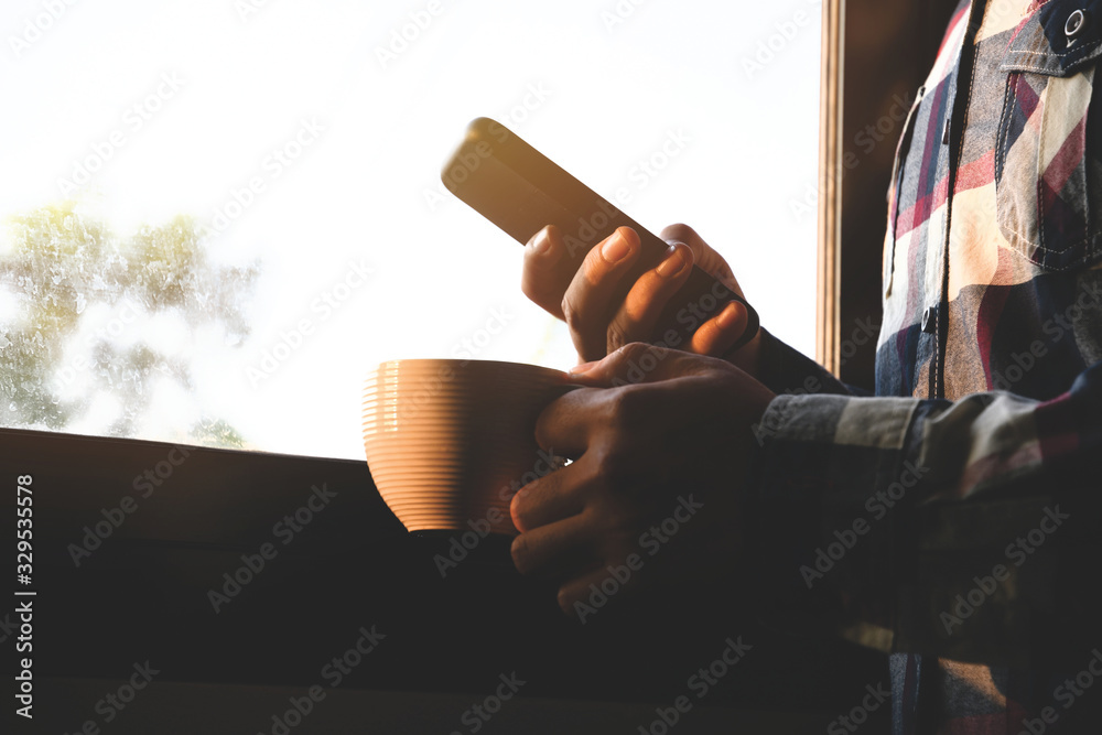 Poster man using smartphone in the room with window background. use smartphone in the morning for social me