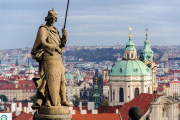 Fototapeta na wymiar St. Wenceslas Statue in front of the Prague castle, city skyline wit St. Nicholas Church in background, sunny day