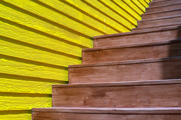 A brown wooden stair with yellow wooden wall