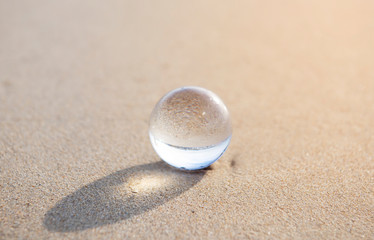 glass ball crystal clear reflecting the sea and beach in the morning