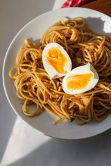 spaghetti with boiled egg on white plate