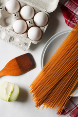 Fototapeta na wymiar pasta and ingredients on white background, eggs, spaghetti, onion