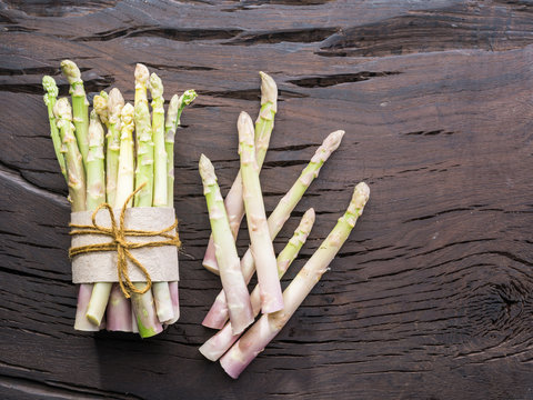 White fresh asparagus sprouts on wooden table. Royal vegetable. Top view.
