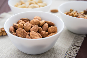 diet food concept, almonds, walnuts and cashew nuts on a wooden table