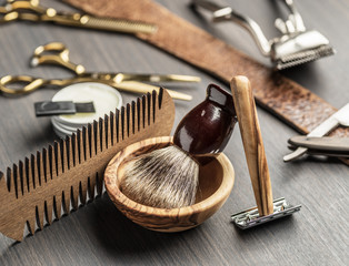 Classic grooming and hairdressing tools on wooden background.