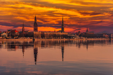 Obraz premium Cityscape of Riga Latvia with Reflections on a Quiet Still River at Sunset
