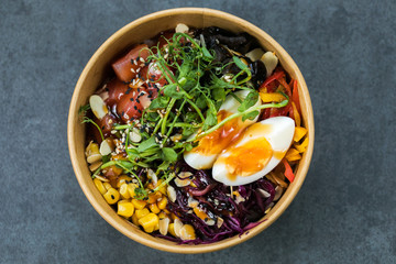 Hawaiian salmon fish poke bowl with, cucumber, tomato, sesame seeds and seaweeds. Diet food