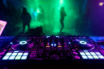 DJ mixer in the booth on the background of the dance floor