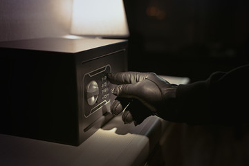 Burglar tries to find the combination code of a safe   