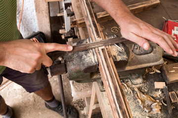 Male carpenter working on old wood in a retro vintage workshop.