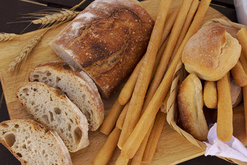 Different kind of fresh bread on wooden table, natural light