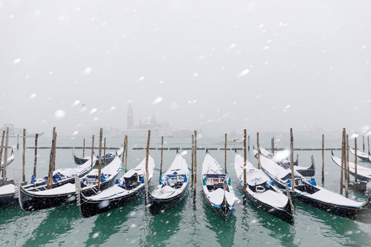 Winter snowfall in the city of Venice, gondolas covered by snow and in the background the San Giorgio Maggiore church, Venice, Veneto, Italy, Europe