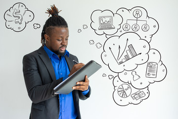 Black man writing in paper with hand drawn business sketches. Serious busy guy generating business plan. Concentrated handsome young businessman doing paperwork and examining document. Report concept