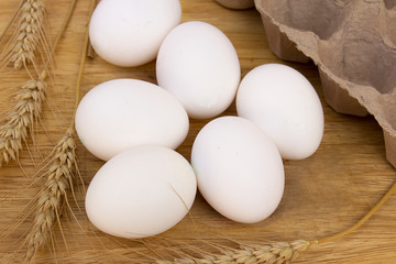 White eggs on wooden table, natural light