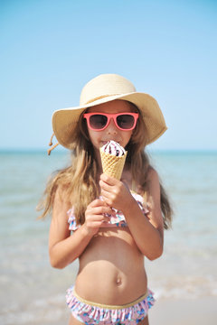 Cute girl has fun on the beach. Summer time.