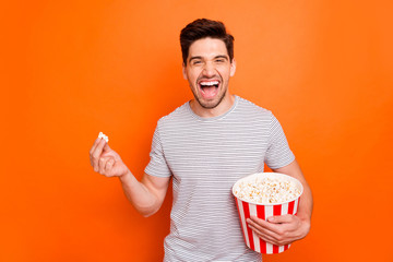 Photo of attractive crazy funky guy watch television humor show eat popcorn laughing out loud wear...