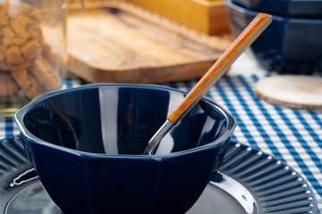 Classic blue ceramic tableware on checkered tablecloth close up