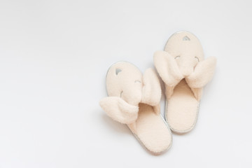 Soft pink fur slippers in shape of rabbit on white background.Top view. Copy space