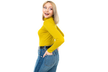 Fototapeta premium sexy blonde girl in a tight-fitting lemon blouse and jeans posing sideways on a white background