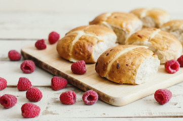 Traditional hot cross buns served with fresh raspberry. Easter food