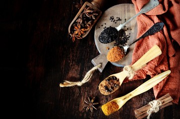 Mix of spices on a dark wooden background.