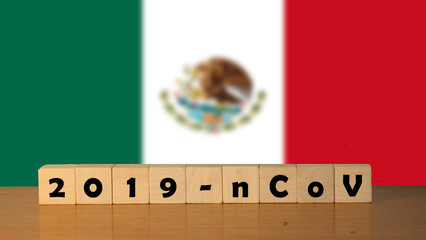 Coronavirus 2019-nCov words made of wood blocks. Covid 19 concept background with Mexico flag for article and news.