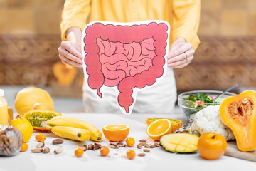 Holding bowel model with variety of healthy fresh food on the table. Concept of balanced nutrition...