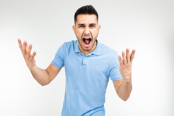 Fototapeta premium handsome guy in a blue t-shirt screaming at the camera on a white isolated background