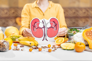 Holding human kidneys model with variety of healthy fresh food on the table. Concept of balanced...