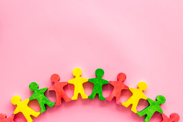 Set of wooden people figures on pink desk. Human resources, management, hiring concept