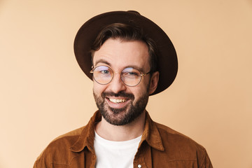 Happy young unshaved man in hat isolated